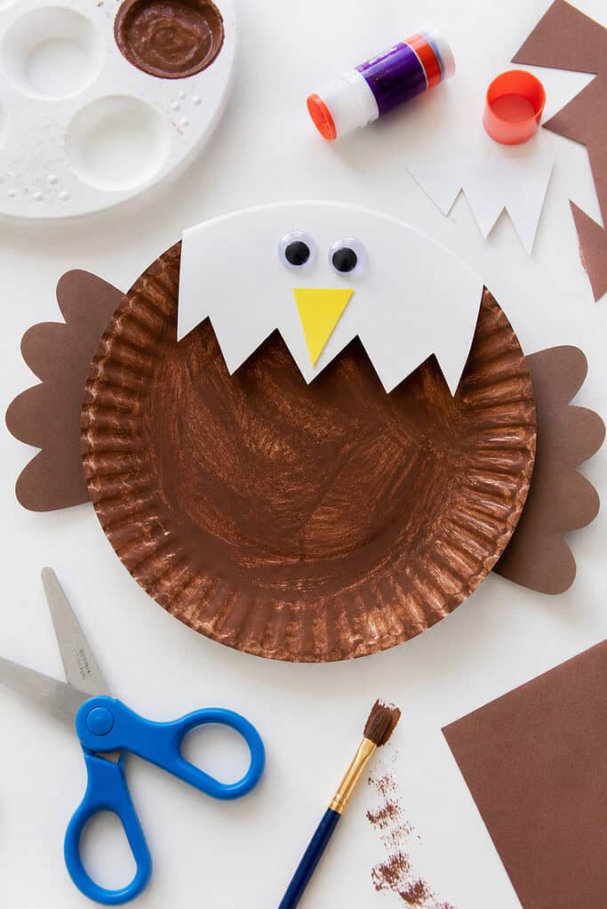 A handmade bald eagle created from a paper plate painted a rich, slightly textured brown to form the body.