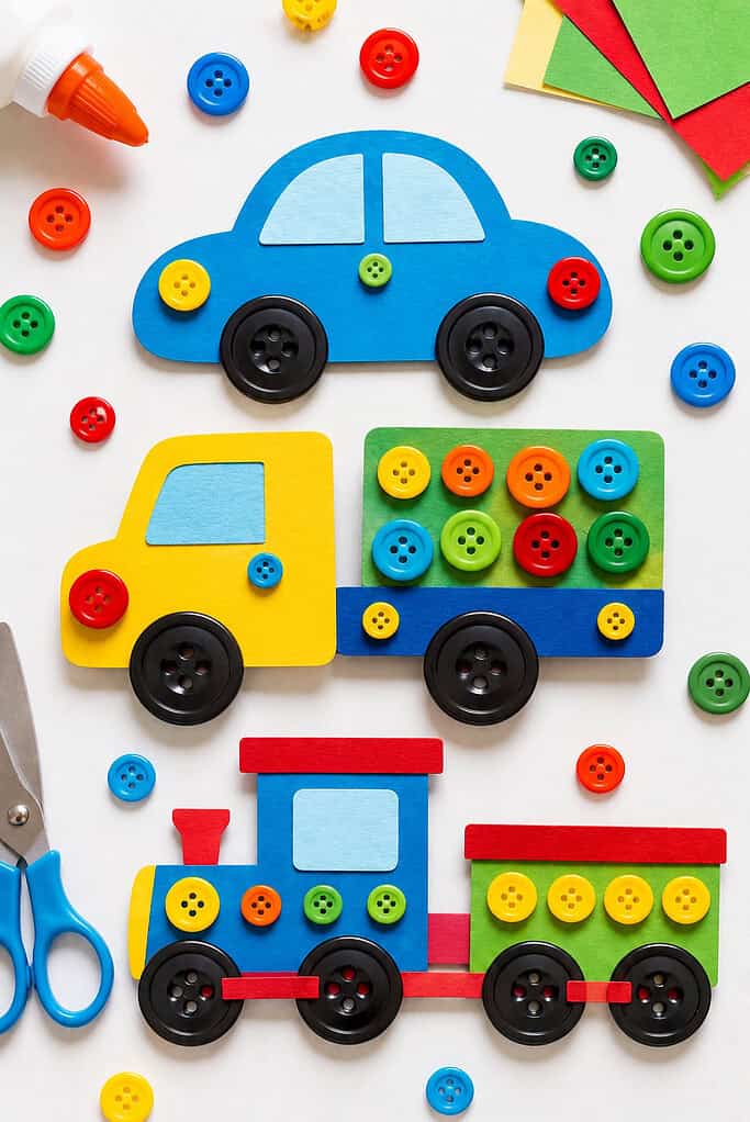 handmade vehicle crafts cut from thick cardstock or cardboard, including a simple car, truck, and train, all decorated with colorful buttons
