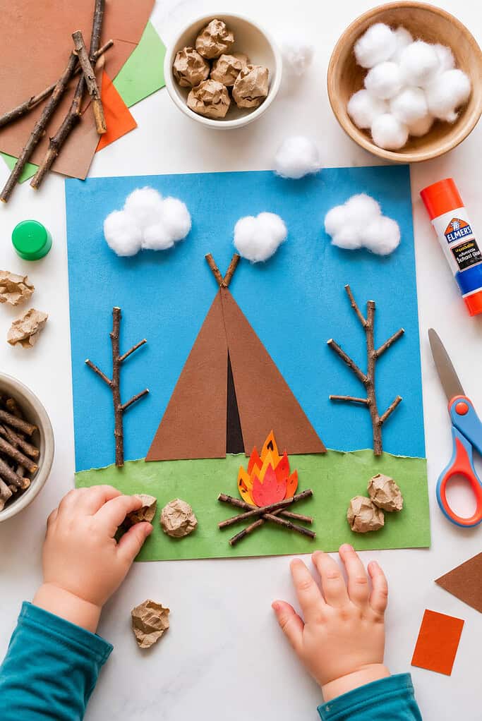 a completed toddler-friendly camping collage craft made on blue cardstock