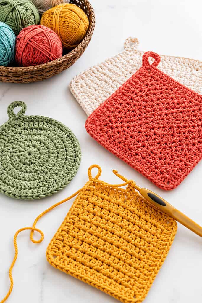 a small set of thick cotton crochet pot holders in simple square and circular designs