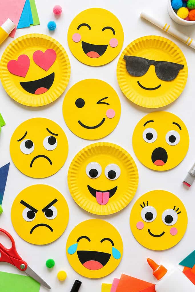 handmade emoji faces created from bright yellow cardstock circles and paper plates