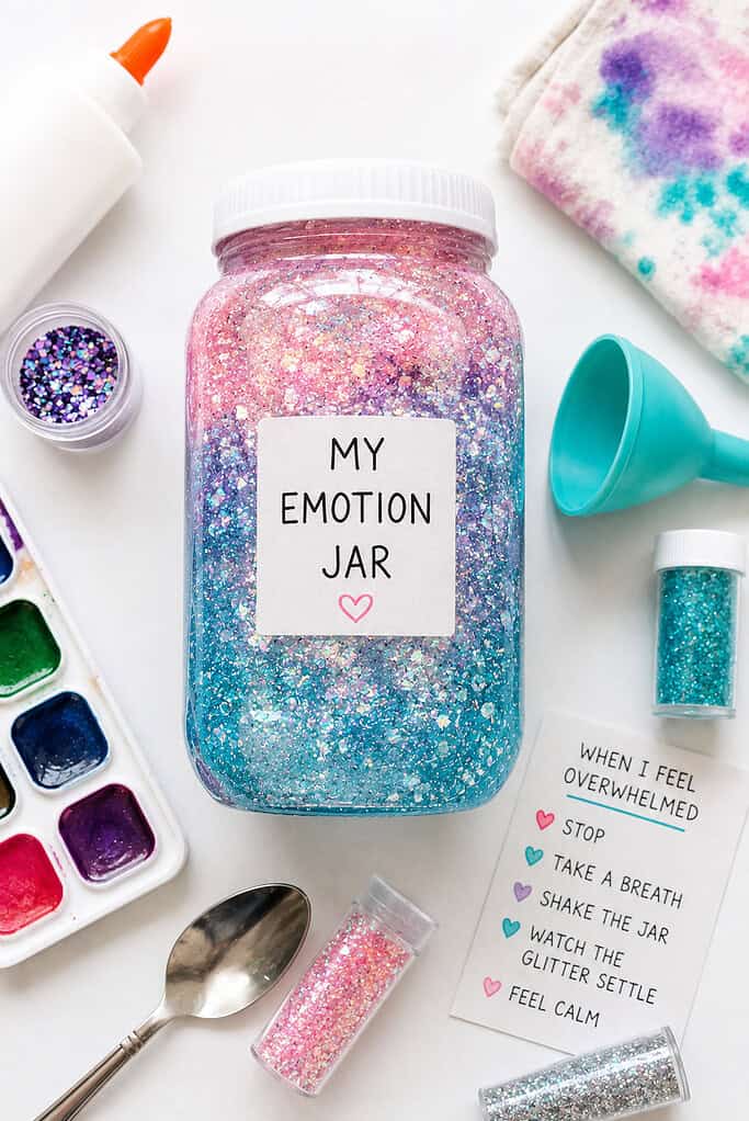 a clear sensory jar filled with shimmering glitter water in soft emotional colors