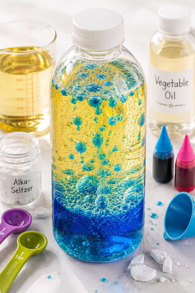 one clear plastic sensory bottle filled two-thirds with translucent golden vegetable oil and the remaining portion with vividly colored water