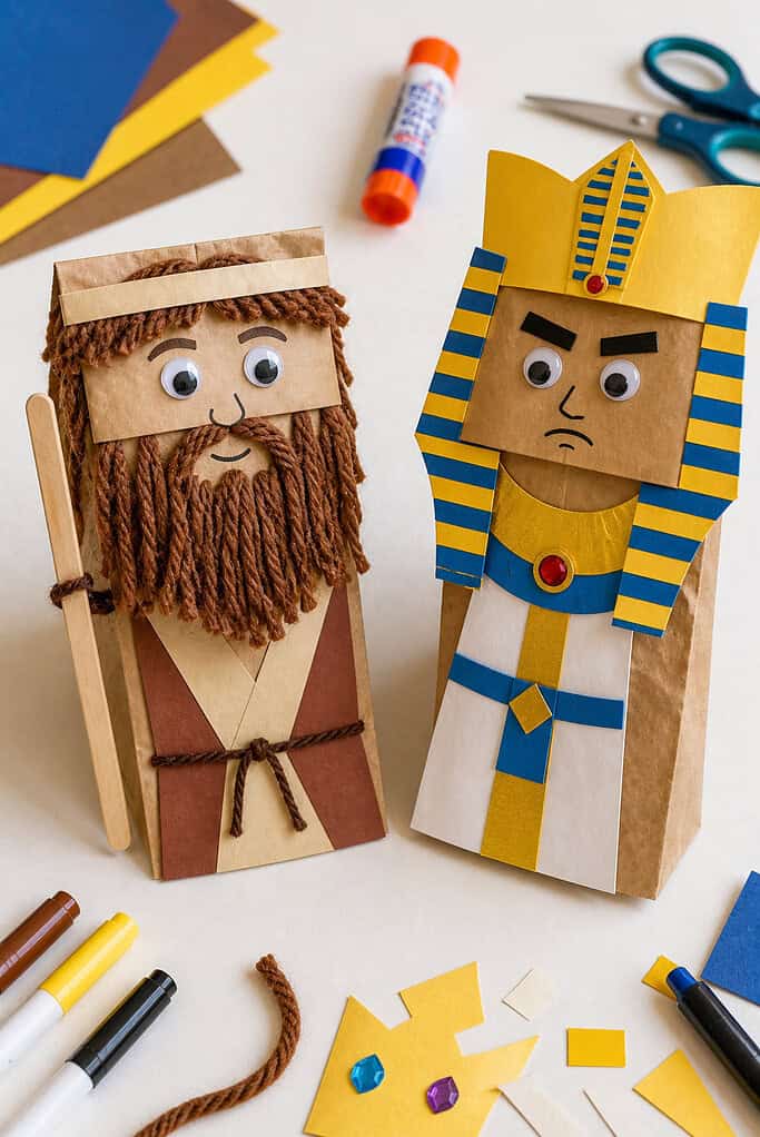 two finished paper bag puppets standing upright or slightly angled toward each other