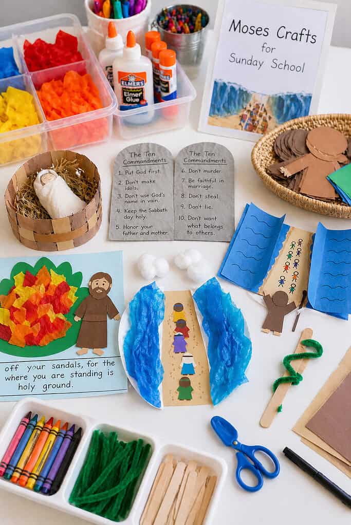 a well-organized craft station layout with multiple simple Moses-themed crafts prepared and partially assembled