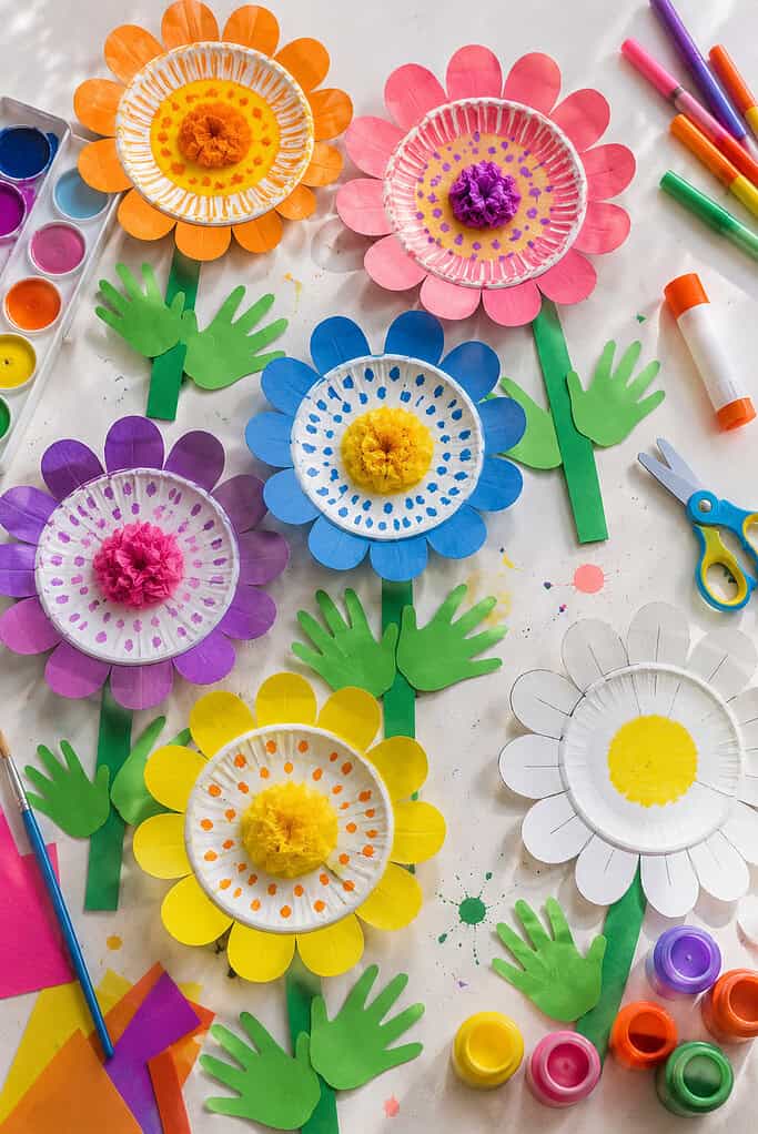 several paper plates transformed into cheerful flowers arranged like a blooming garden across the table