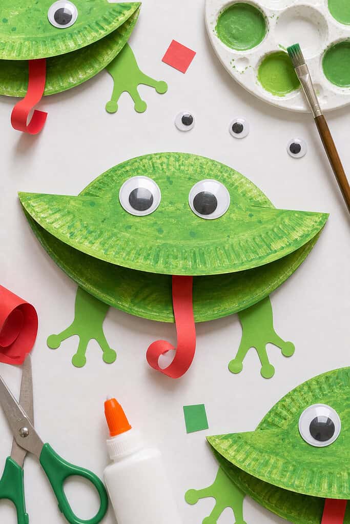 A paper plate painted a vibrant, slightly uneven green with visible brush strokes for a natural, handmade look