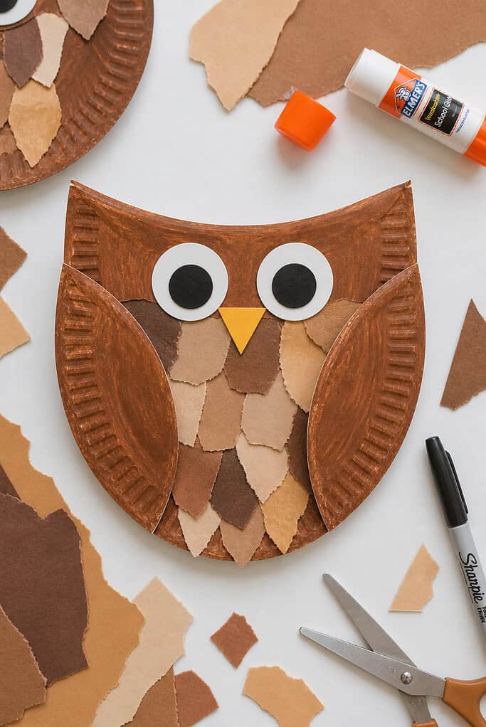 A paper plate cut in half, with each side folded inward toward the center to form two simple wings.