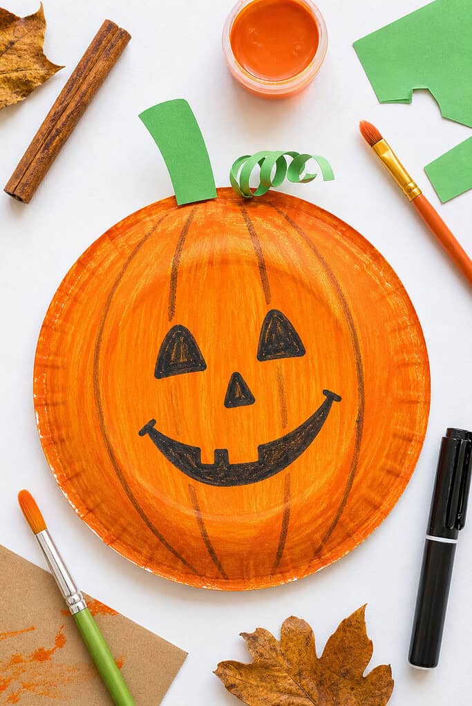 A standard paper plate turned upside down (back side facing up) and painted a rich, warm orange