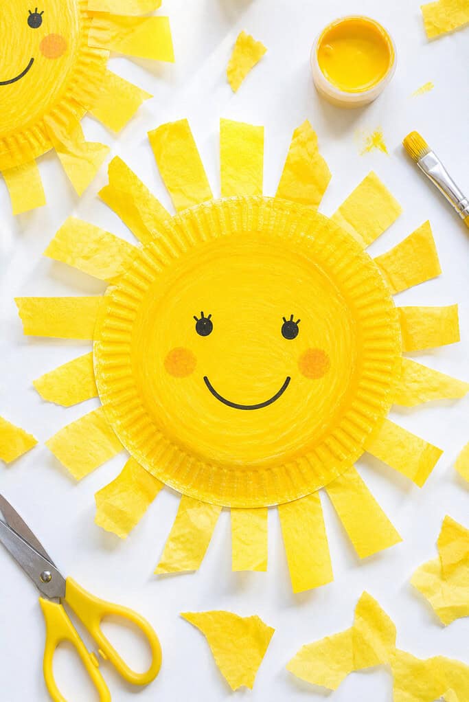 A paper plate painted a rich, sunny yellow with visible brush strokes for a natural, childlike finish