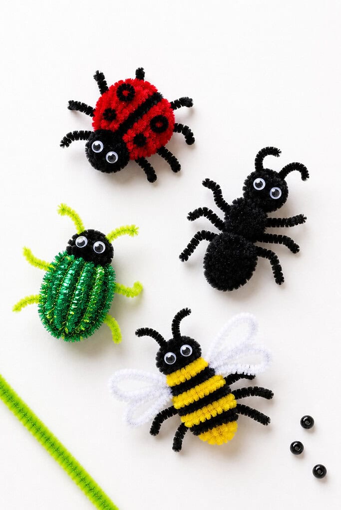 a small assortment of handmade insects crafted from colorful fuzzy pipe cleaners,