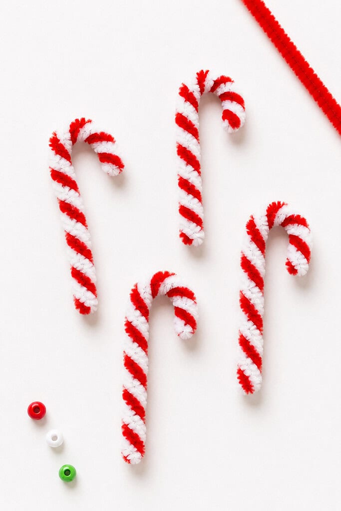 several handmade candy canes crafted from red and white fuzzy pipe cleaners twisted tightly together