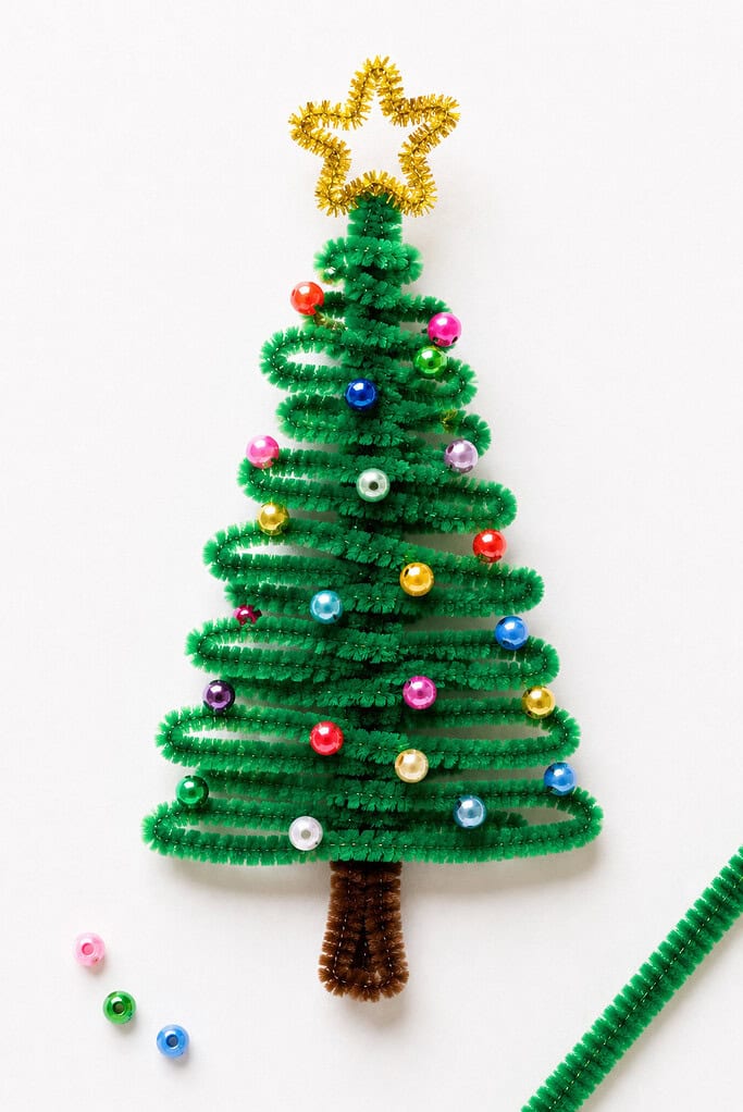 a handmade Christmas tree crafted from twisted green fuzzy pipe cleaners shaped into a cone