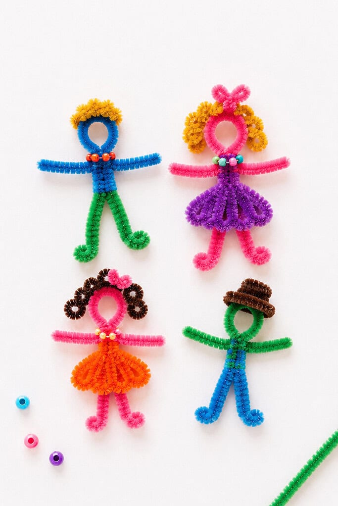a small group of handmade people figures crafted from colorful fuzzy pipe cleaners