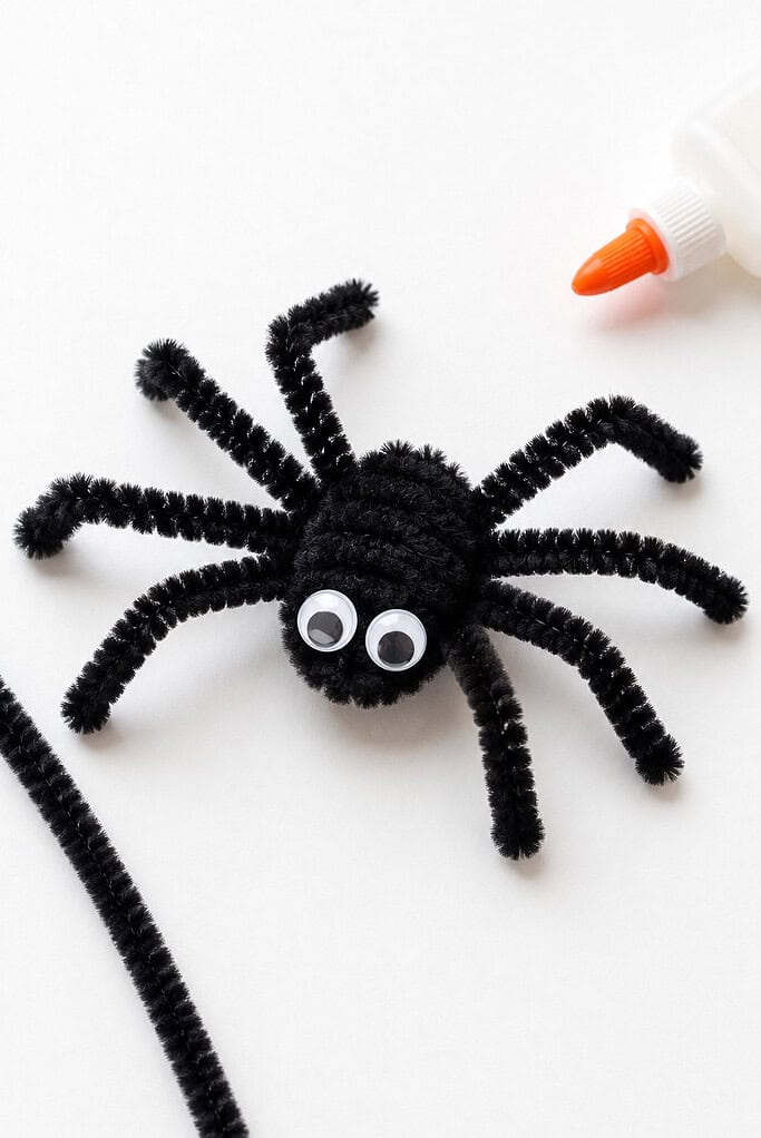 a handmade spider crafted from black fuzzy pipe cleaners twisted together at the center
