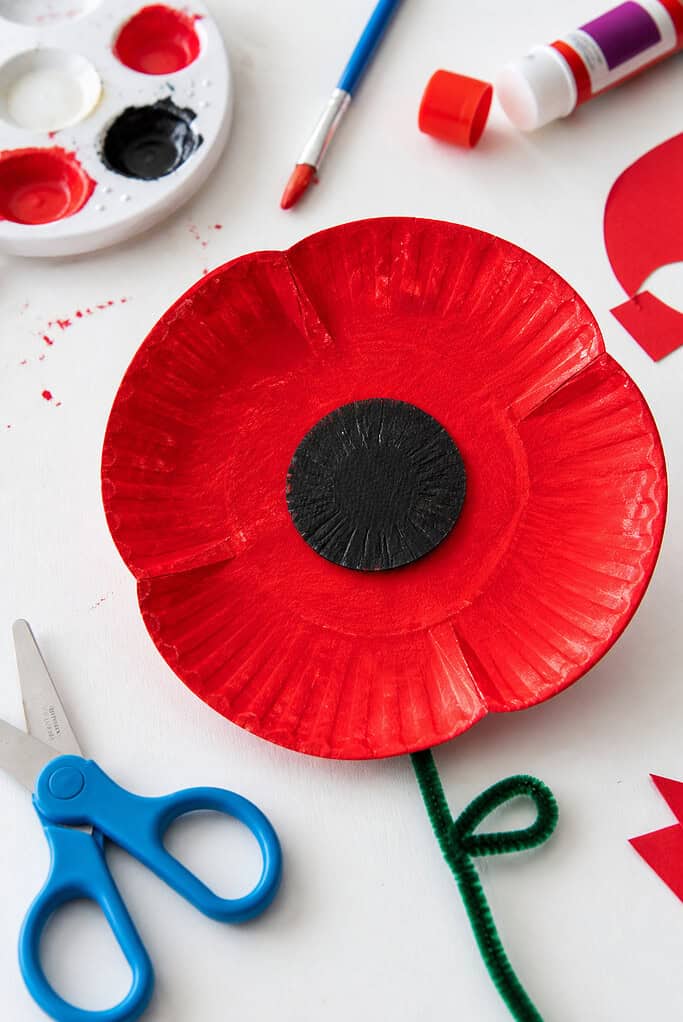 A handmade poppy flower created from a cut paper plate shaped into soft, rounded petals.