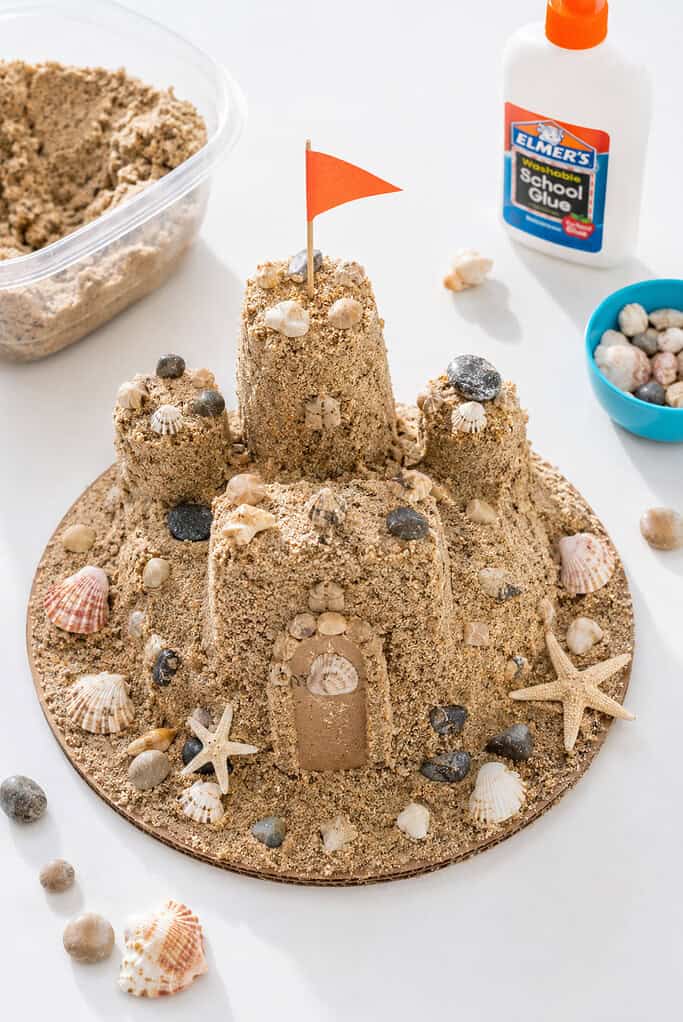 A miniature sandcastle craft built on a sturdy cardboard base using real craft sand and glue.