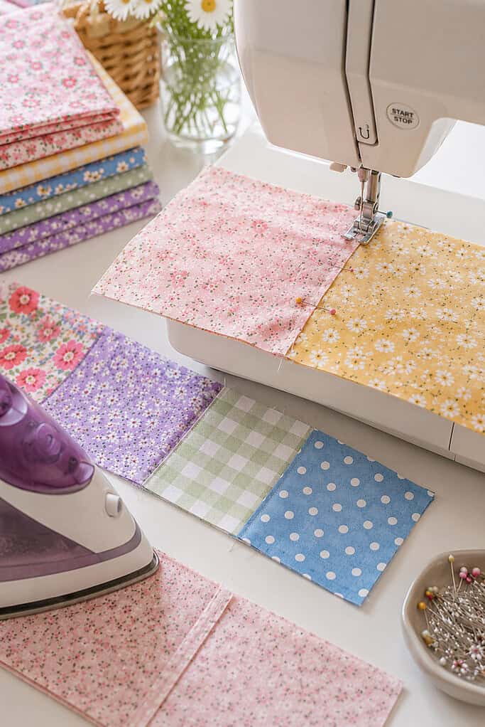 colorful patchwork squares being sewn together into rows for a tote bag.