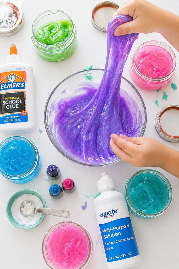 a mixing bowl filled with freshly made slime being stretched or lifted.