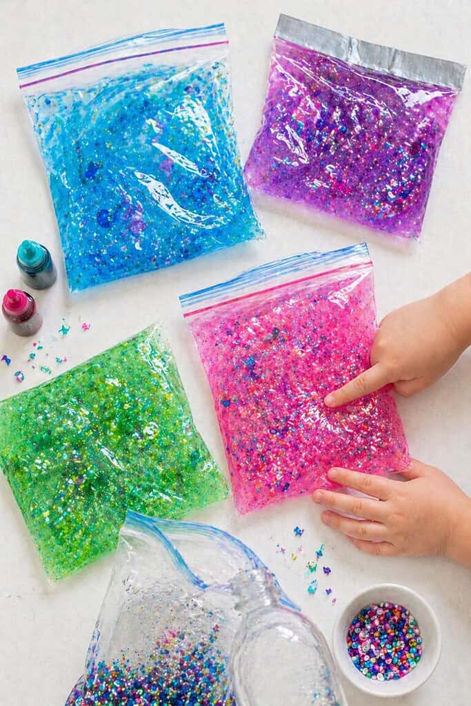clear zip-top bags filled with hair gel tinted with food coloring, suspended glitter, and small beads or sequins