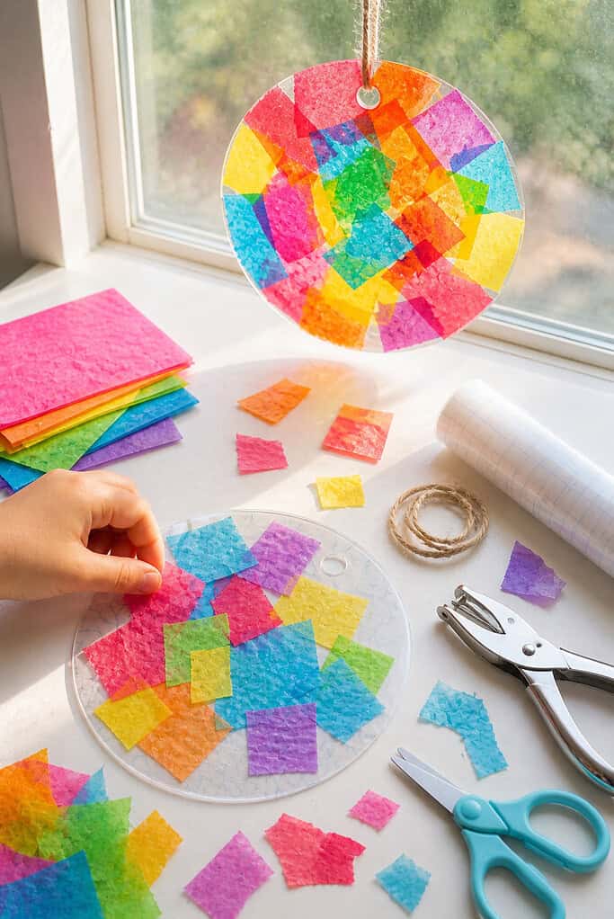 a circular suncatcher made from contact paper as the focal point, displayed both in-progress and finished