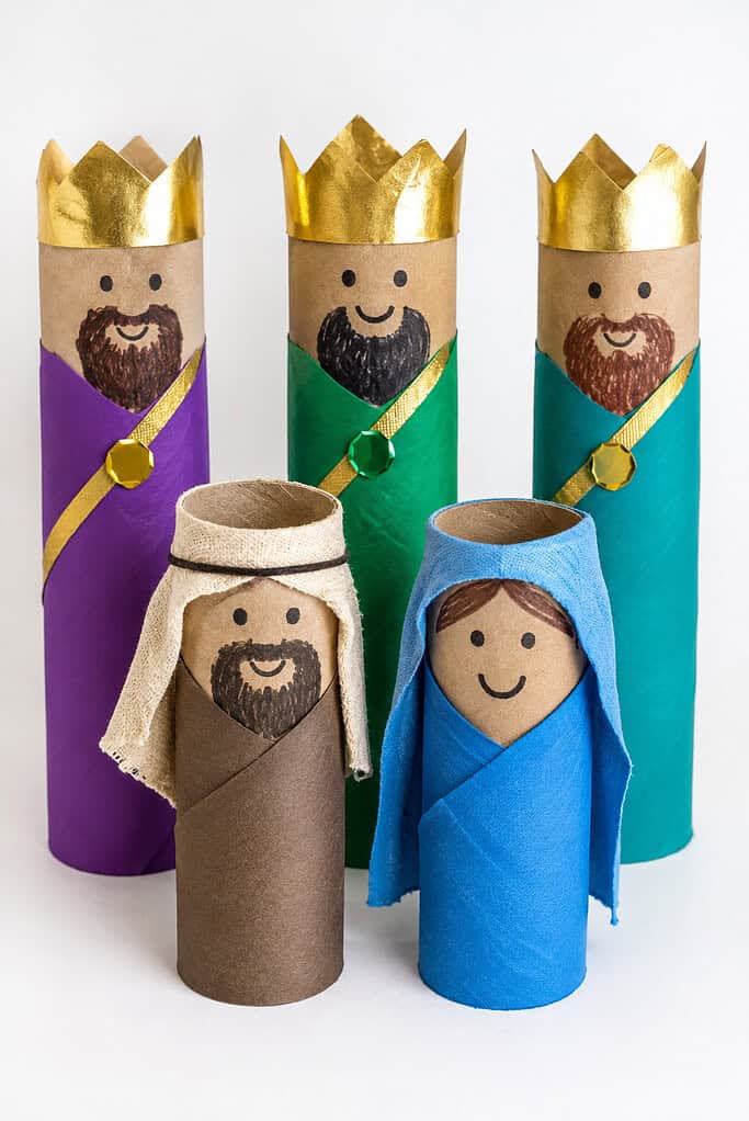 handmade toilet paper roll nativity figures with wise men, Mary, and Joseph standing on a white table