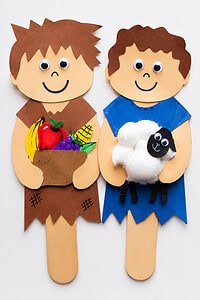 Cain and Abel using colorful construction paper cutouts, popsicle sticks, googly eyes, crayons, markers, cotton balls, and glue.