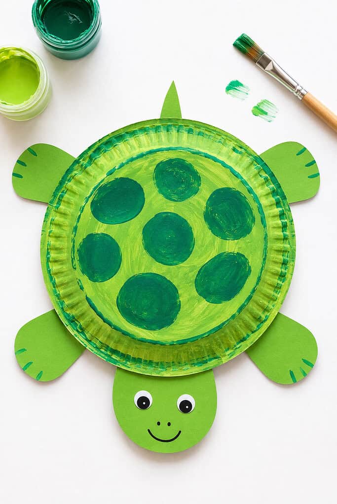 a painted green paper plate that serves as the turtle's shell.