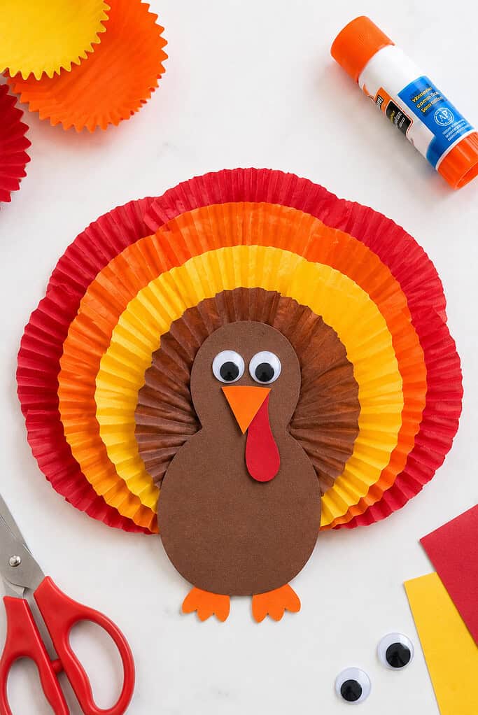 A charming turkey craft made from layered cupcake liners arranged into a fan-shaped tail of ruffled feathers.