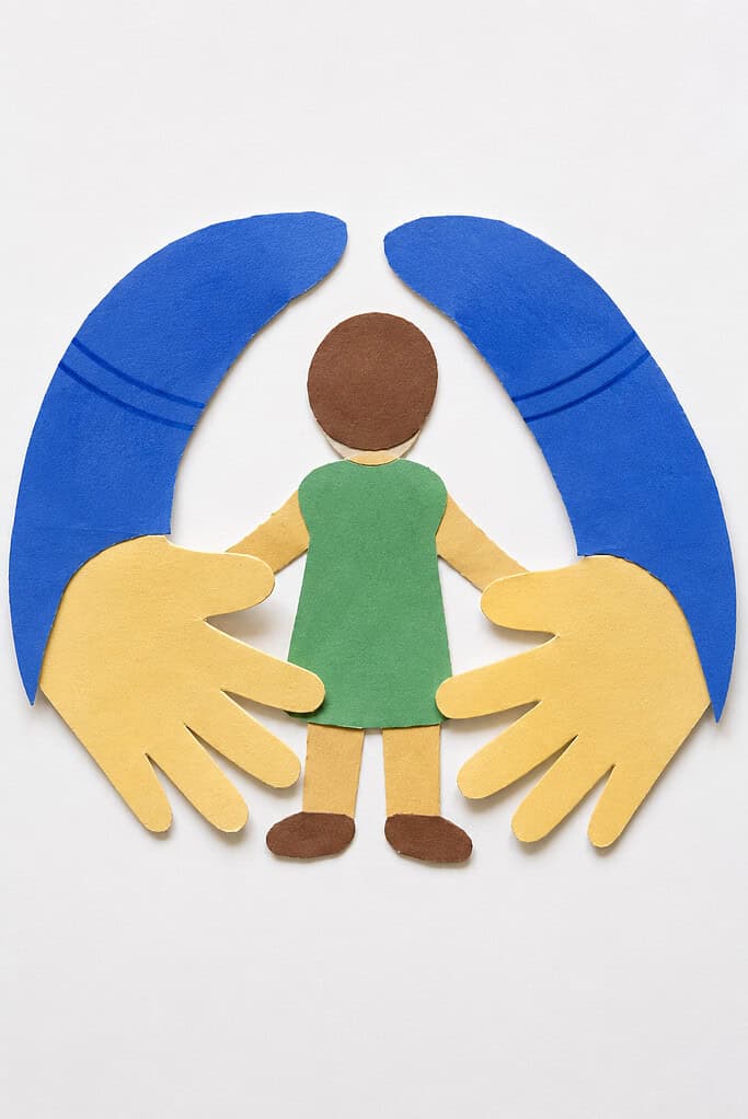 Two large paper handprints with attached arm shapes are positioned wide open as if reaching for a hug.