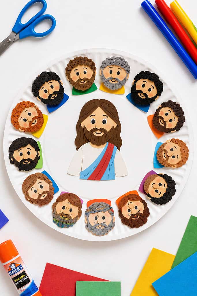 A large white paper plate with a colorful cutout of Jesus securely glued in the middle.