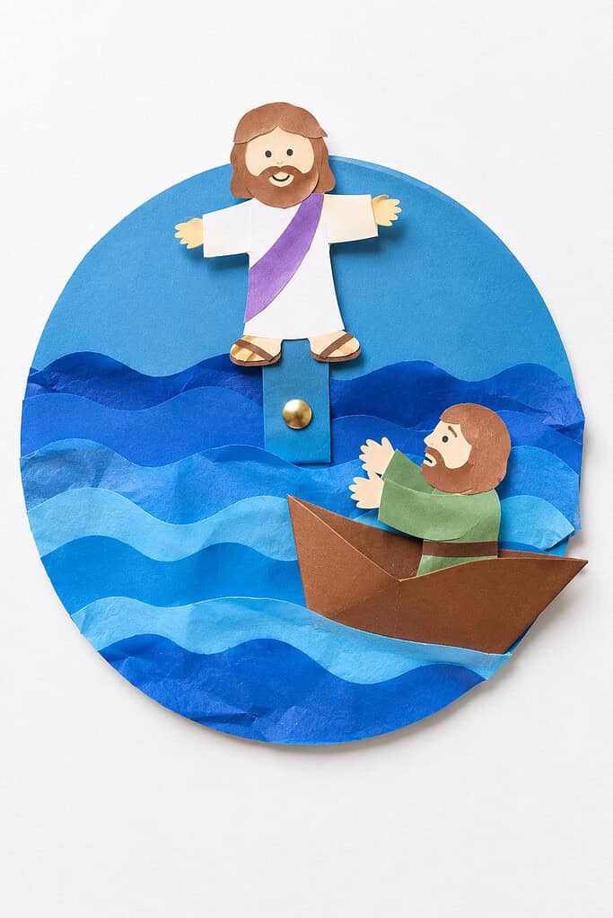 a simple paper Jesus figure positioned on top of a bright blue paper sea made from layered construction paper or tissue paper waves