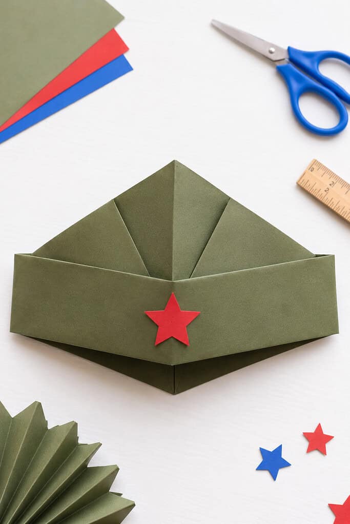 a simple folded-paper soldier cap made from a single sheet of construction paper, sized for a child to wear.