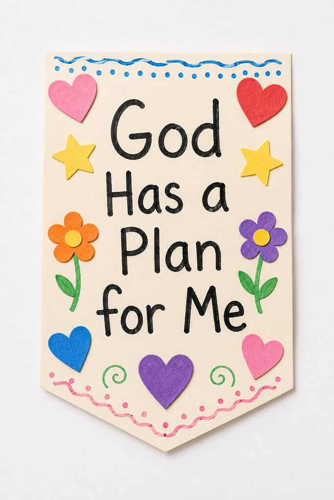 A cream-colored paper card with a blue dotted border, handwritten text reading "God Has a Plan for Me," and decorated with felt cutouts of pink and red hearts, yellow stars, and orange and purple flowers with green stems.