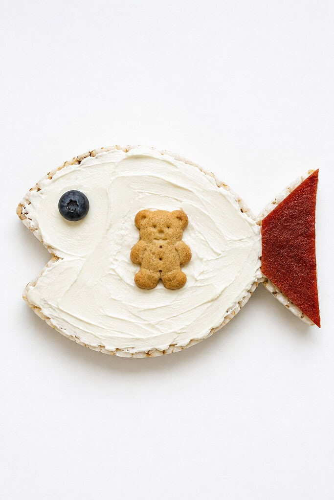 A rice-cake fish with a blueberry eye and a teddy-bear cracker tucked inside for Jonah.