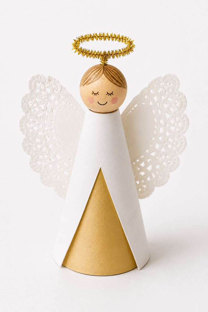 A standing paper cone angel with a bead head, paper doily wings, and a pipe-cleaner halo.