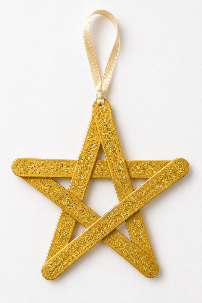 A five-pointed star woven from craft sticks, painted gold with glitter and a ribbon loop for hanging.