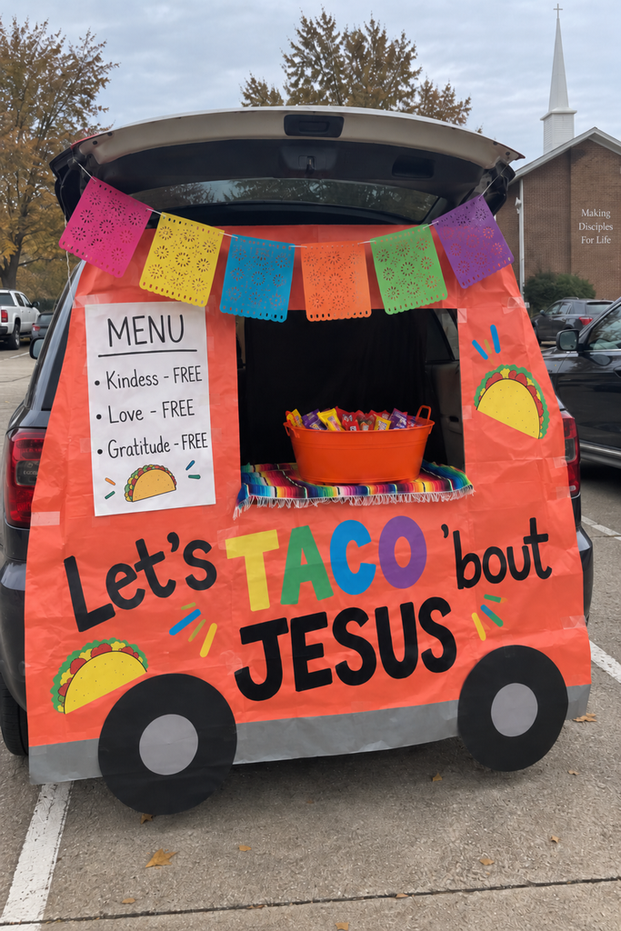 A car decorated as a taco truck reading Let's Taco 'bout Jesus with a papel picado banner and a menu sign.