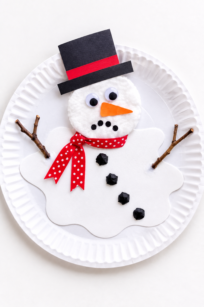 a melting snowman craft with a flat white puddle, a round head, and coal buttons on a paper plate