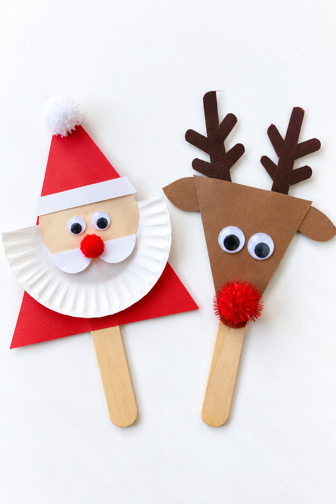 a Santa and a reindeer stick puppet, a red triangle Santa with a beard and hat and a brown triangle reindeer with antlers and a red pom-pom nose, on a white table