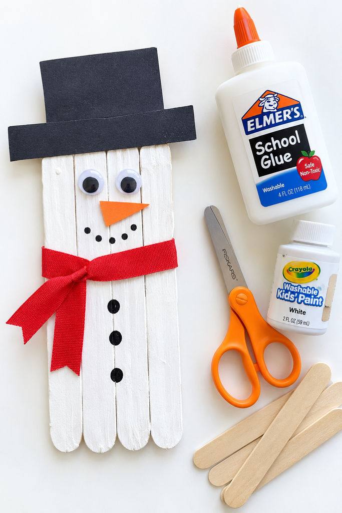 a 3D paper snowman craft made of rolled white paper loops on blue paper with a black hat, dot eyes, an orange nose, buttons, and paper arms on a white table