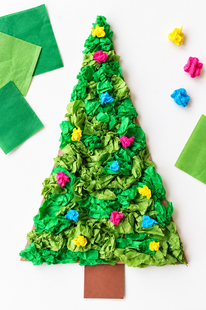 A crumpled green tissue-paper Christmas tree with bright ornaments beside squares of tissue paper.